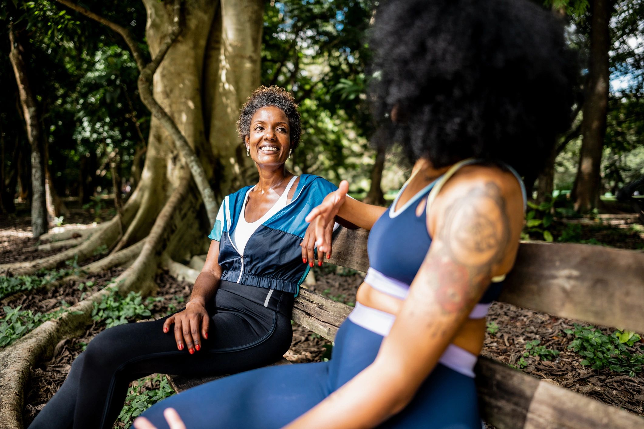 Two African American women sharing a calm, supportive conversation in a park