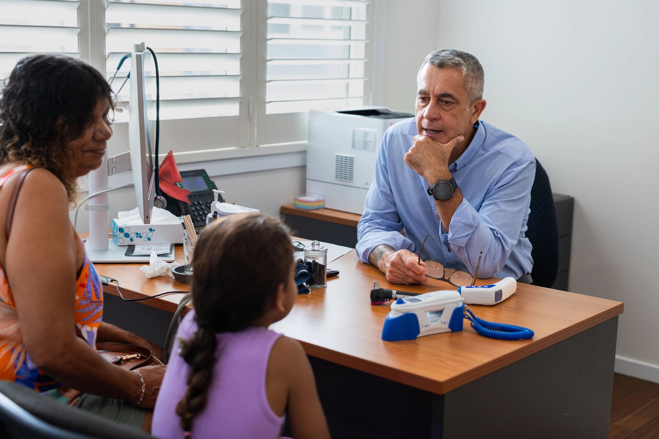 Doctor meeting with a young patient and her grandmother